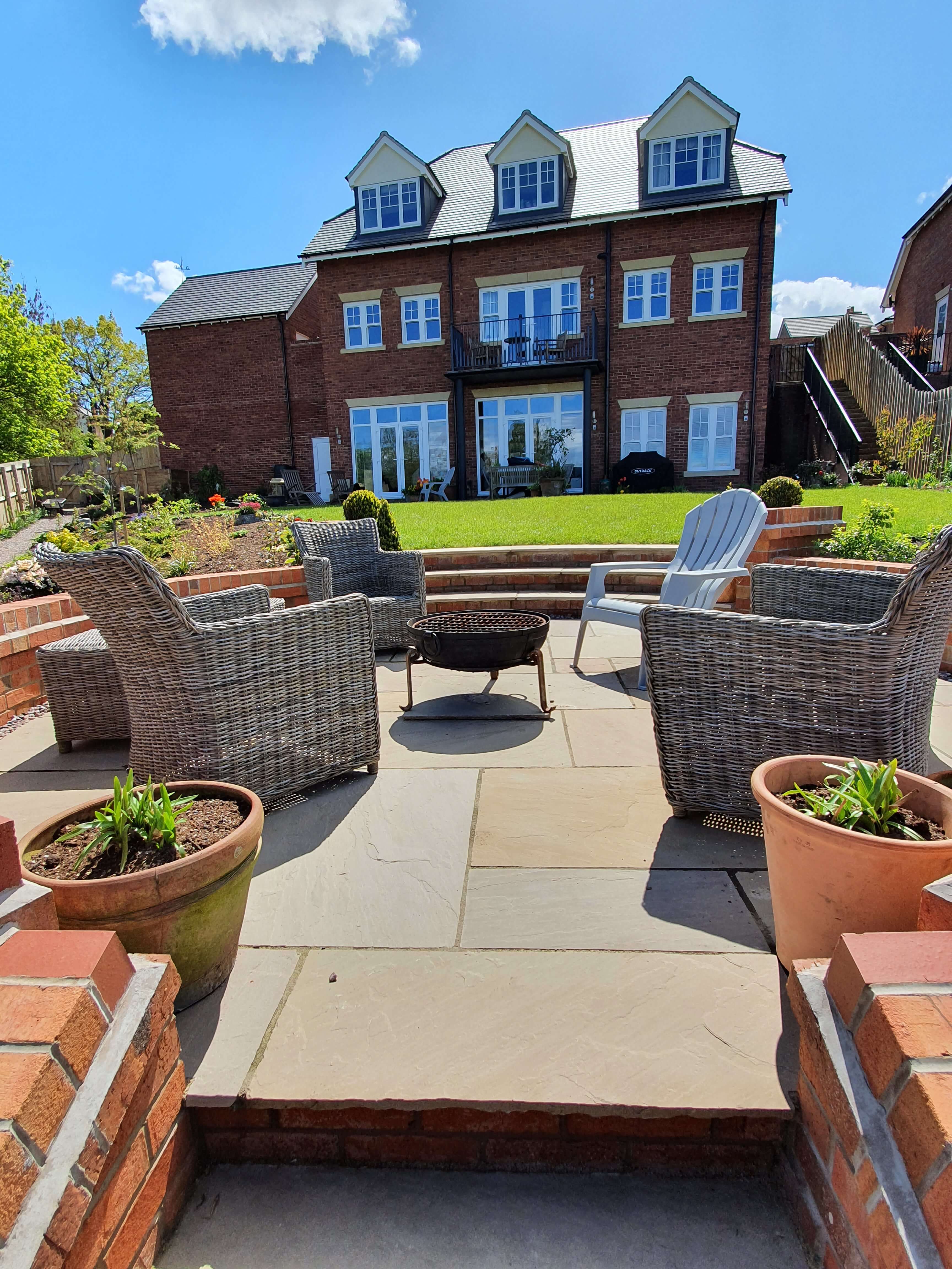 Patio seating area with fire pit and garden views
