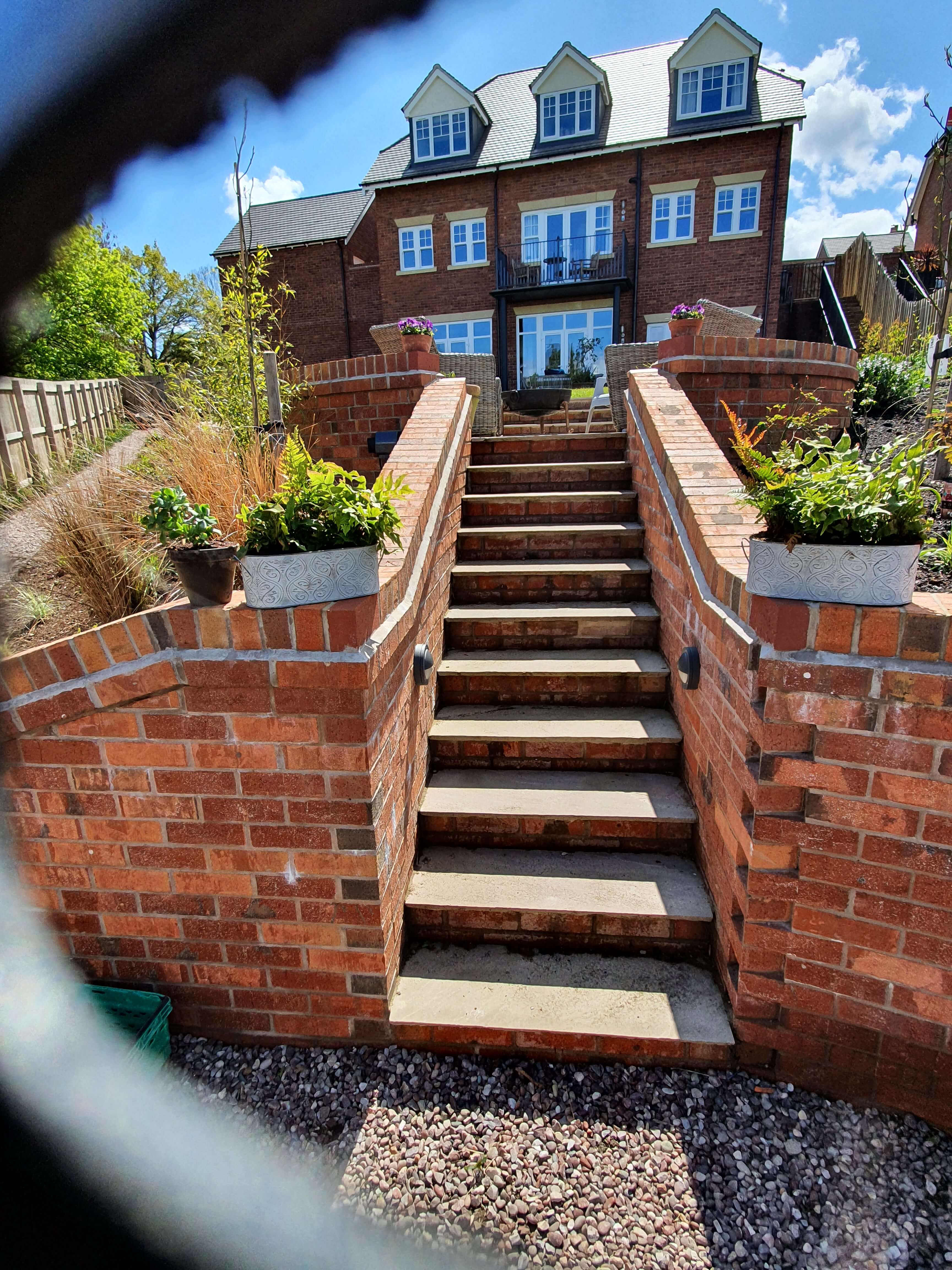 Brick staircase with tiered planters leading to house